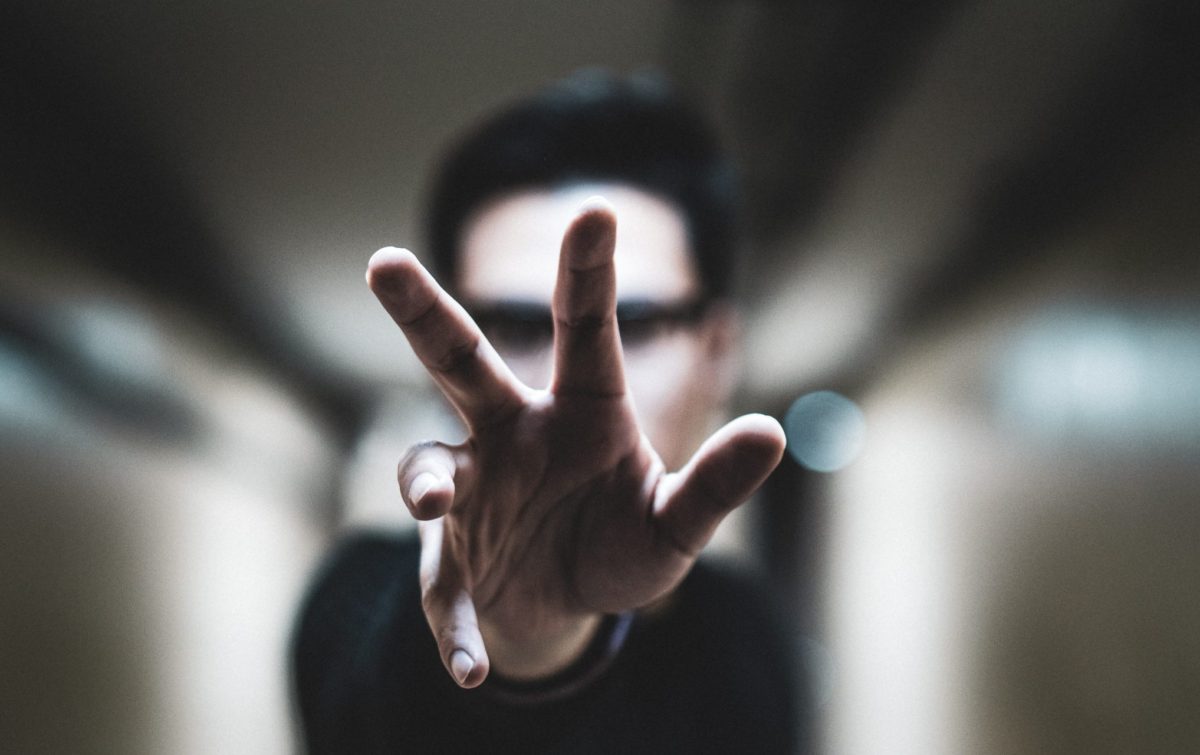 shallow focus photo of person reaching right hand