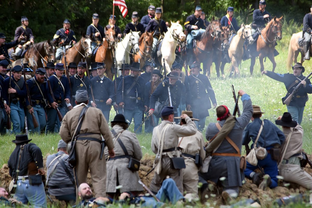 Union infantry and calvary advancing on Confederate line. Civil war reeanactment.