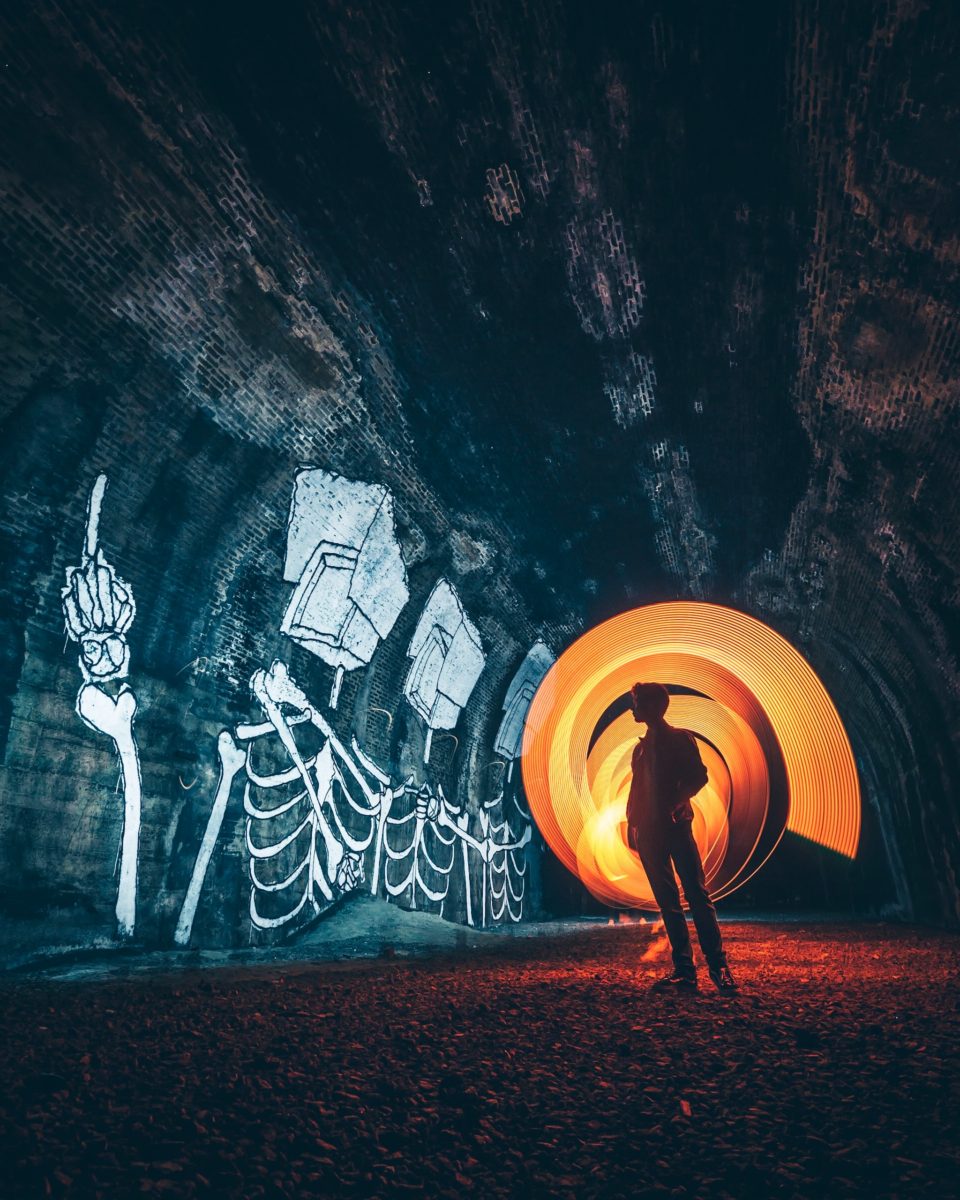 silhouette of person standing inside tunnel